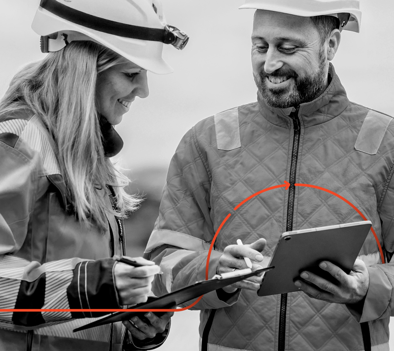 Baustellenleiterinn und Mitarbeiter von noma besprechen sich. Beide haben Tabletts und lächeln.